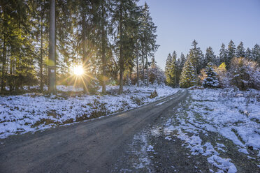 Germany, Lower Saxony, Altenau, Harz Nature Park in winter, hiking path against morning sun - PVCF01193