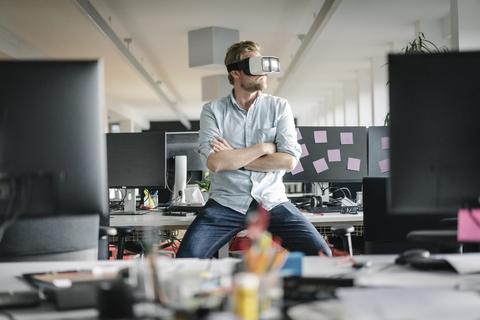 Businessman wearing VR glasses in office stock photo