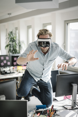 Geschäftsmann trägt VR-Brille im Büro und gibt vor, ein Löwe zu sein, lizenzfreies Stockfoto