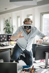 Geschäftsmann trägt VR-Brille im Büro und gibt vor, ein Löwe zu sein - JOSF02034