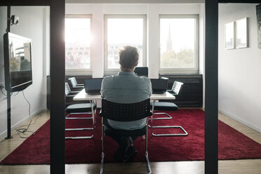 Businessman in conference room of an office with two laptops - JOSF02042