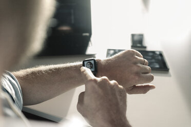 Close-up of businessman with smartwatch showing image of a girl - JOSF02044