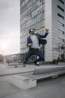 Geschäftsmann mit VR-Brille beim Springen in der Stadt - JOSF02059