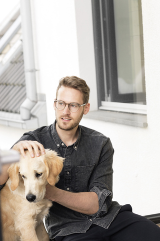 Young man petting dog at the window stock photo