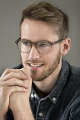 Porträt eines lächelnden jungen Mannes mit Brille - PESF00788