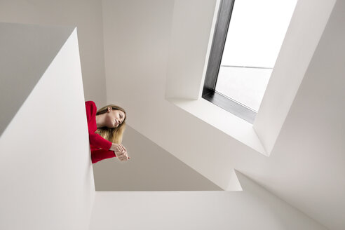 Young woman on upper floor under roof window - PESF00814