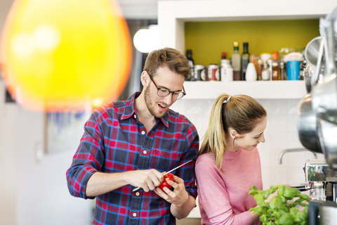 Junges Paar bereitet in der Küche eine gesunde Mahlzeit zu, lizenzfreies Stockfoto