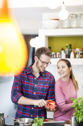 Glückliches junges Paar bei der Zubereitung einer gesunden Mahlzeit in der Küche - PESF00818