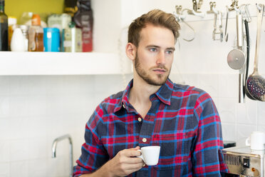 Pensive young man with cup of espresso in kitchen at home - PESF00819