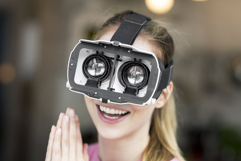 Glückliche junge Frau mit VR-Brille, lizenzfreies Stockfoto