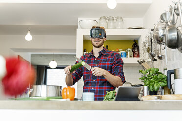 Glücklicher junger Mann mit VR-Brille beim Kochen in der Küche - PESF00852