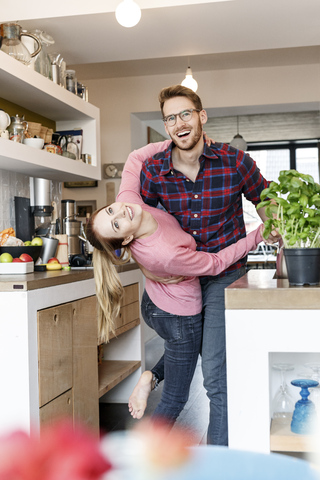Glückliches junges Paar tanzt in der Küche, lizenzfreies Stockfoto