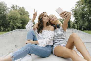 Two happy young women taking a selfie in a skatepark - KNSF03072