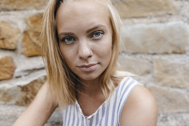 Portrait of young woman at natural stone wall - KNSF03086