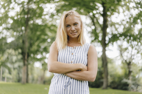 Portrait of smiling young woman in a park stock photo