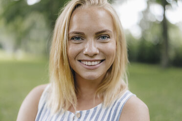 Portrait of smiling young woman in a park - KNSF03121