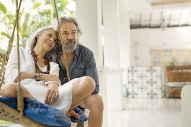 Senior man taking selfie at poolside while his wife is playing the guitar - SBOF00923