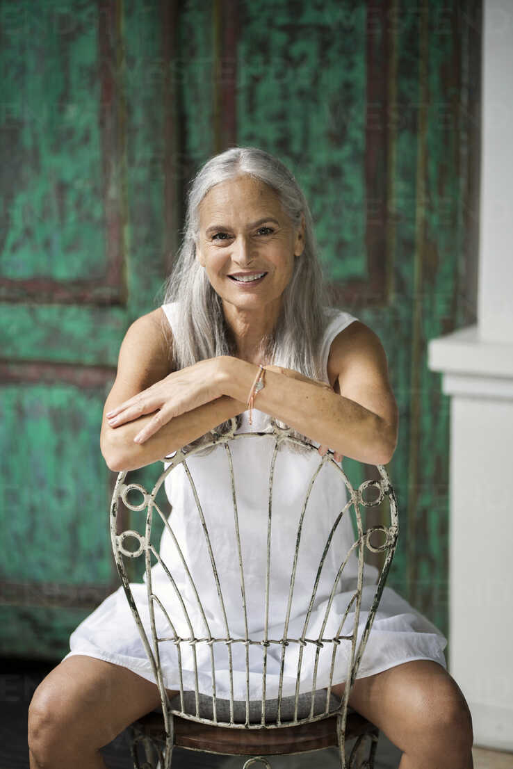 Portrait of a beautiful senior woman, sitting on a chair stock photo