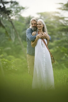 Hübsches älteres Paar, das sich in einer tropischen Landschaft umarmt - SBOF00970
