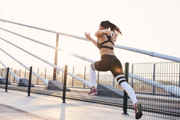 Young woman sprinting in the city - BSZF00121