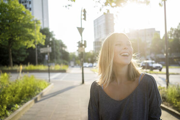 Portrait of laughing young woman at backlight - KNSF03164