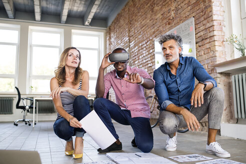 Team of architects discussing the rebuilding of a loft office, using 3D goggles - HAPF02440