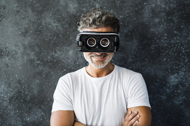 Mature man looking through VR glasses backwards - HAPF02464