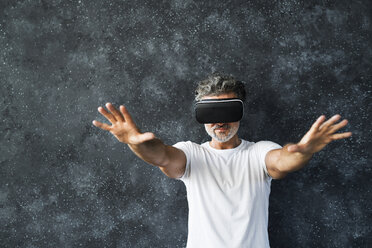 Reifer Mann mit VR-Brille streckt die Hände aus - HAPF02466