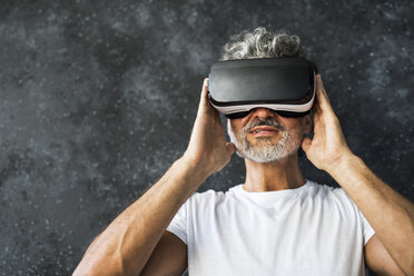 Mature man looking through VR glasses - HAPF02468