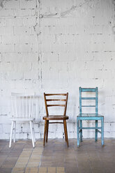 Empty chairs against white brick wall - HAPF02501