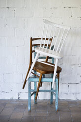 Empty chairs against white brick wall - HAPF02502