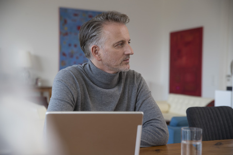 Businessman working on computer in apartment stock photo