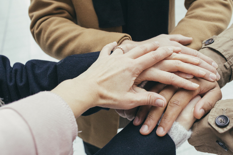 Group of friends putting hands together stock photo