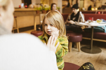 Young woman with daughter and friends in a cafe - KMKF00084