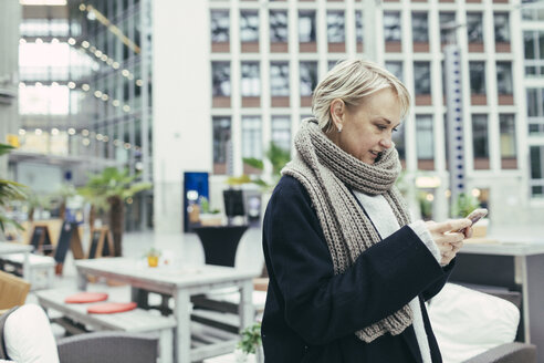 Blonde Frau benutzt ein Mobiltelefon - KMKF00087