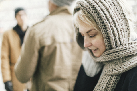 Lächelnde blonde Frau mit gestricktem Schal, lizenzfreies Stockfoto