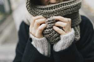 Woman's hand holding knitted scarf, close-up - KMKF00089