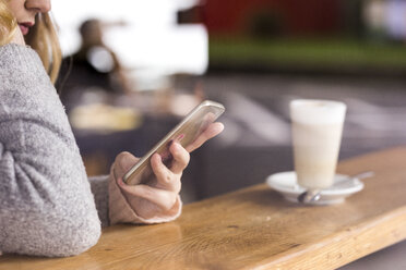 Smartphone in der Hand einer Frau - FMKF04659