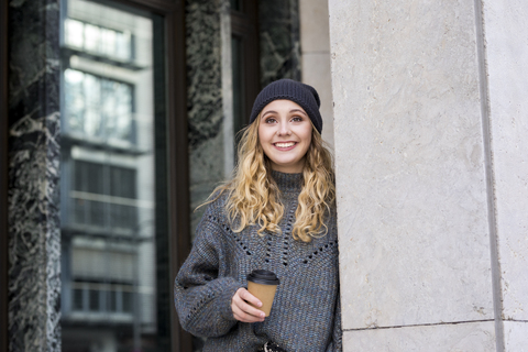 Porträt einer modischen jungen Frau mit Kaffee zum Mitnehmen im Herbst, lizenzfreies Stockfoto