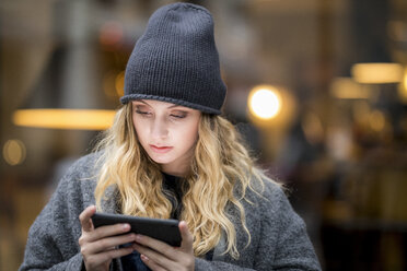 Portrait of serious young woman using smartphone - FMKF04674