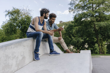 Zwei Freunde teilen sich ein Handy im Skatepark - KNSF03172