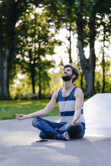 Mann sitzt im Skatepark und meditiert - KNSF03181