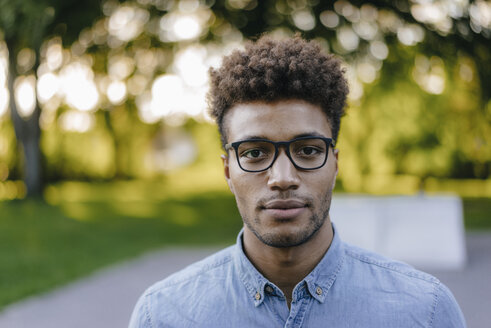 Portrait of young man wearing glasses in park - KNSF03188