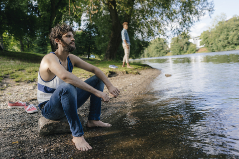 Mann entspannt sich am Wasser, lizenzfreies Stockfoto