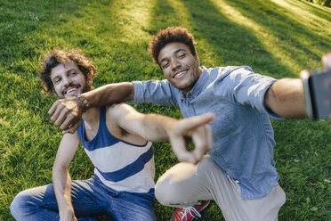 Zwei glückliche Freunde posieren für ein Selfie in einem Park - KNSF03236