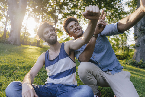 Zwei glückliche Freunde posieren für ein Selfie in einem Park, lizenzfreies Stockfoto
