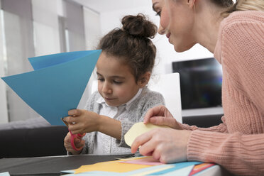 Mother and little daughter tinkering with colored fancy paper - GDF01191