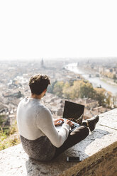 Italy, Verona, tourist using laptop, observation point - GIOF03579