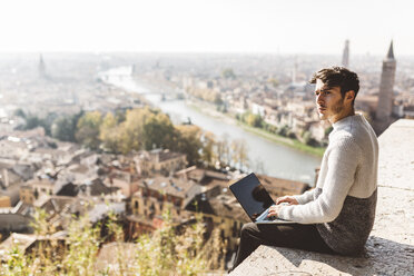 Italy, Verona, tourist using laptop, observation point - GIOF03581