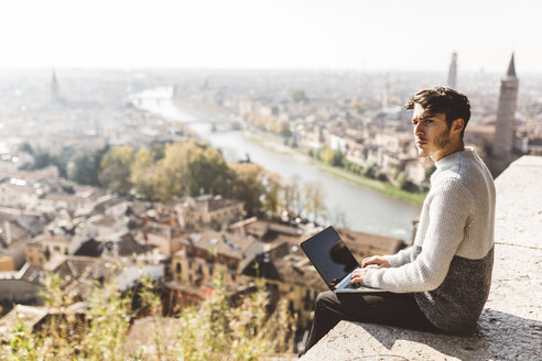 Italien, Verona, Tourist mit Laptop, Aussichtspunkt - GIOF03581